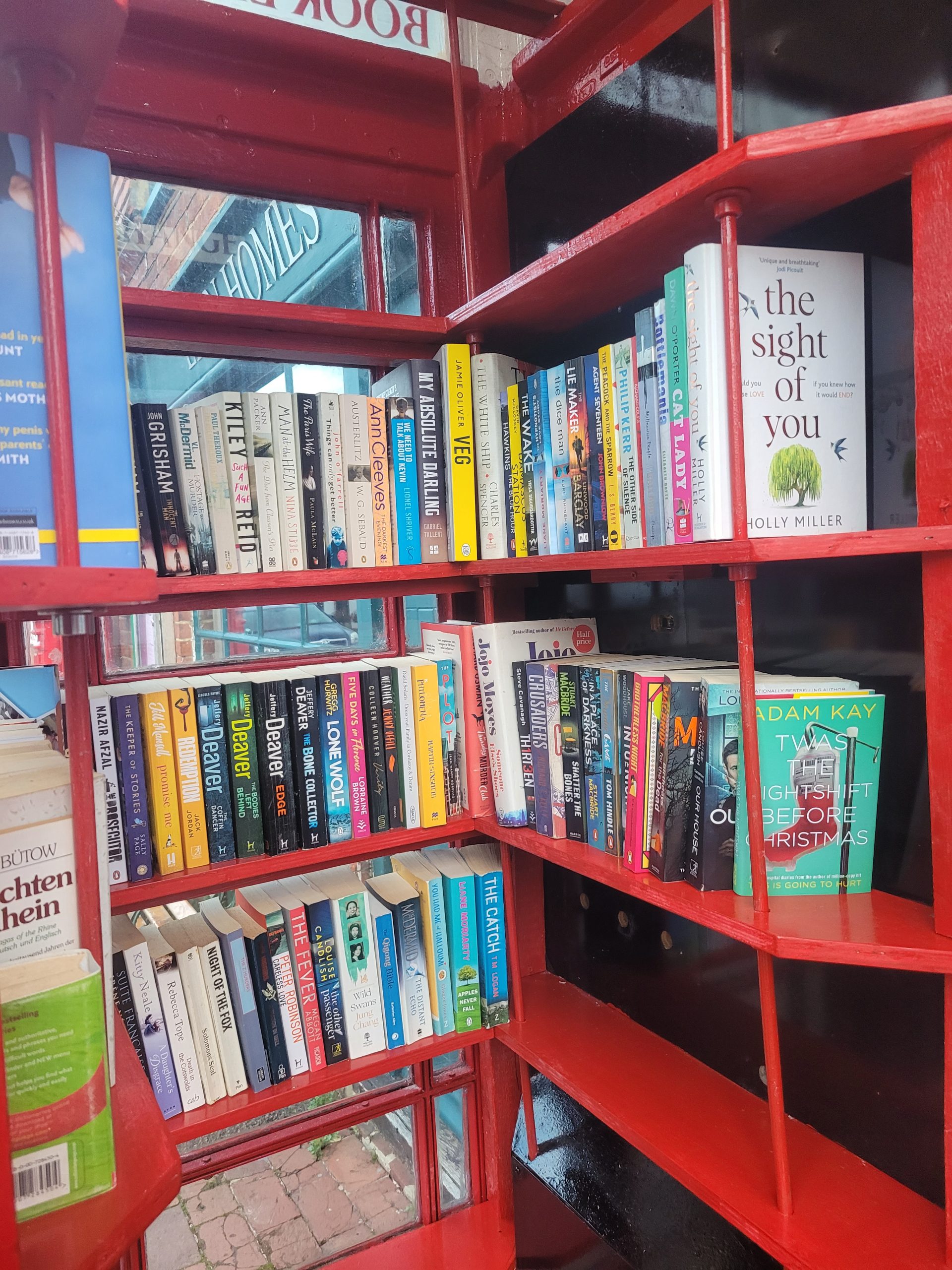 Books on shelves inside a red telephone box